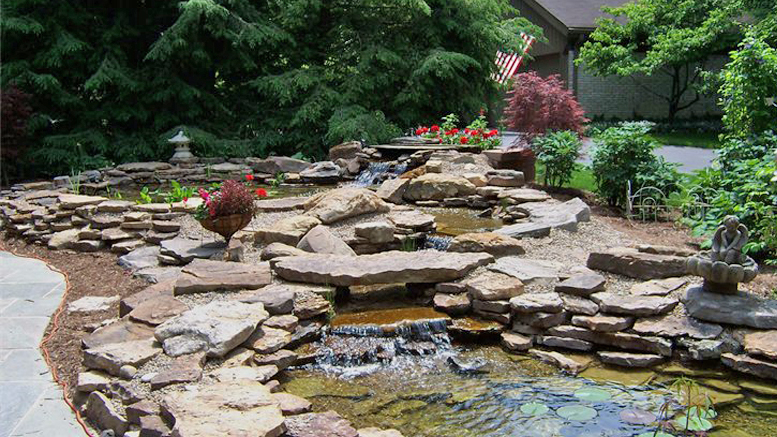 A beautiful and tranquil water feature is pictured in this outdoor setting created by Tell Three Friends. Photo by: Susie Burns