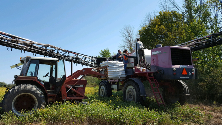 Loading cover crop seeds into a hi boy at the Hults Environmental Learning Center in Albany. Photo provided.