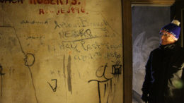 Ron Morris, a Ball State history professor, investigates the unheated third floor of the building next to the opera house which was used as a green room, and dressing rooms for opera acts. The performers signed their names all over the space. Photo provided.