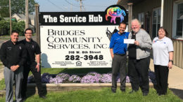 Belle Tire representatives present a check to Bridges Community Services. Photo provided.
