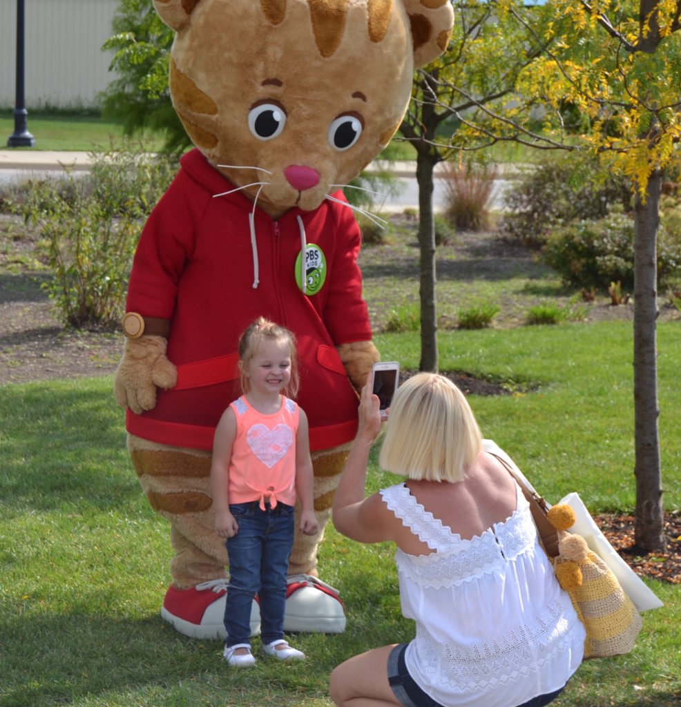 Daniel Tiger poses for a photo with a new friend at Be My Neighbor Day 2017. Photo provided.