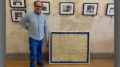 Mark Perretta stands beside the 40"x50" mount and frame he crafted surrounding lyrics handwritten by Roger Waters of Pink Floyd. Photo provided