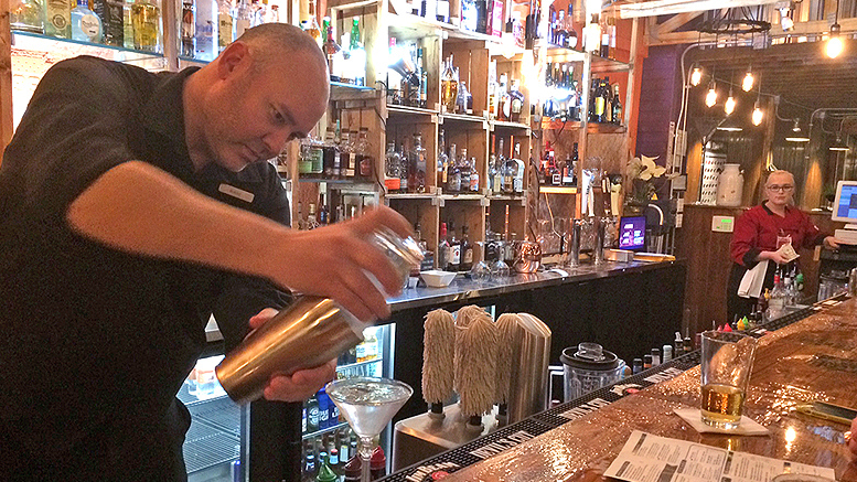 Lahody’s bartender Bobby Replogle pours a vodka martini. Photo by: John Carlson