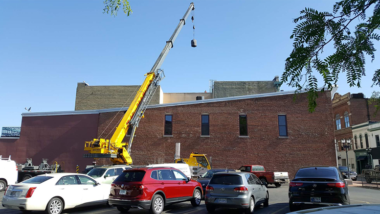 Bullock Heating & Cooling is pictured moving an HVAC unit downtown.