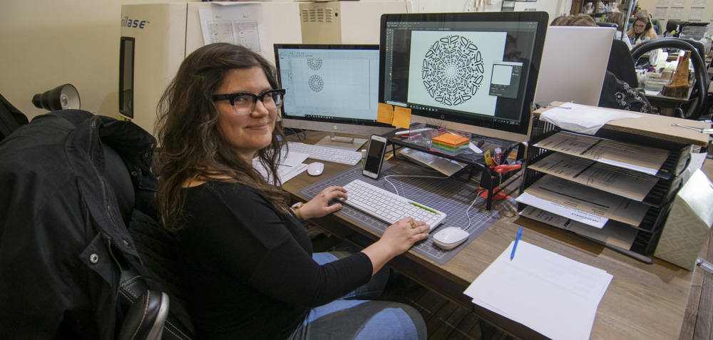 JoAnna, a Heidi J Hale artist is pictured working on a "Namedalla" design prior to sending it to the laser engraving unit. Photo by: Mike Rhodes