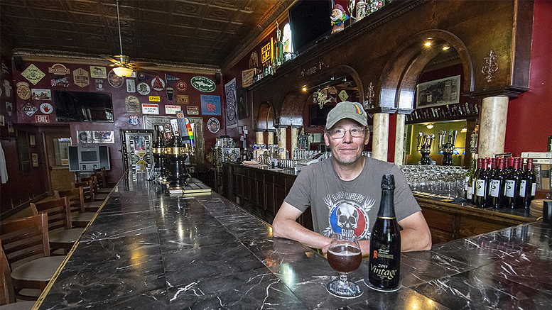 Chris Piche is pictured at the bar with a bottle of Rodenbach 2011 Vintage Flemish Red/Brown Sour Ale—one of the most unique beers made by Rodenbach. Photo by: Mike Rhodes