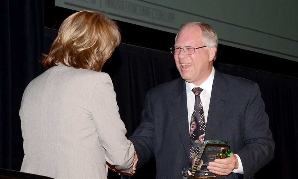 Ron Fauquher, IC board chair is pictured presenting the "Excellence in Mentorship" award to Delaina Boyd.