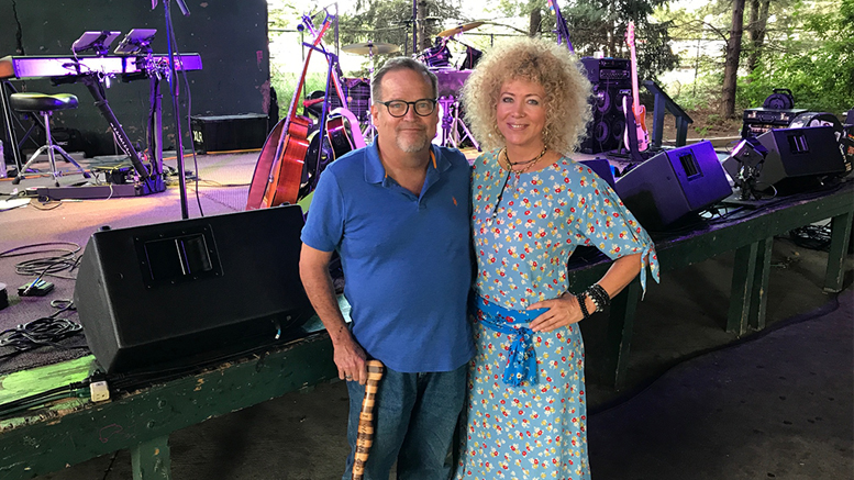 Jennie DeVoe poses with John Carlson. The undulating object trailing down his right pant leg is a beautiful banded cane she had made for him. Photo by: Dave Murray