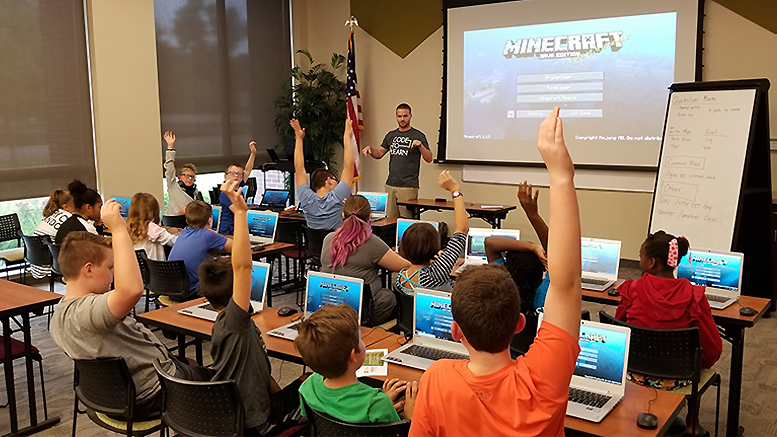 Ryan Hunter, co-founder of TechWise Academy, leads a Minecraft Party in which students get to learn about command blocks and play online in a safe environment. File photo