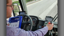 A BSU bus driver is pictured utilizing a new digital tracking system developed by a Capstone Connector team of students. On the left, the driver is holding a blue tablet that utilized an older manual paper entry method. Photo courtesy of Huseyin Ergin