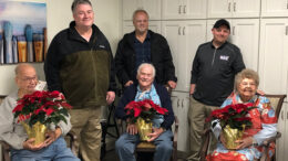 Woof Boom Radio staff members Mitch Henck, Brian Casey, and Zack Johnson are pictured with Sugar Fork Crossing nursing home residents during a Project Poinsettia delivery. Photo by: Lindsey Martin