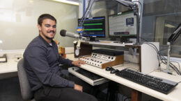 Ball State TCOM student Isaac Dirrim is pictured in the Woof Boom Radio News Center during his recent internship. Photo by: Mike Rhodes