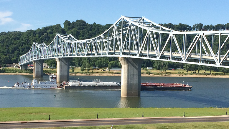 A powerful tugboat pushes barges past Madison’s Riverboat Inn. Photo by: Nancy Carlson