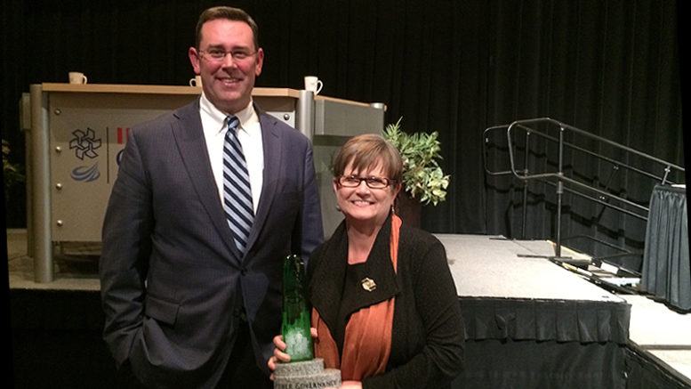 Jud Fisher is pictured with Juli Metzger and the John W. and Janice B. Fisher Governance Award she received. Photo provided.