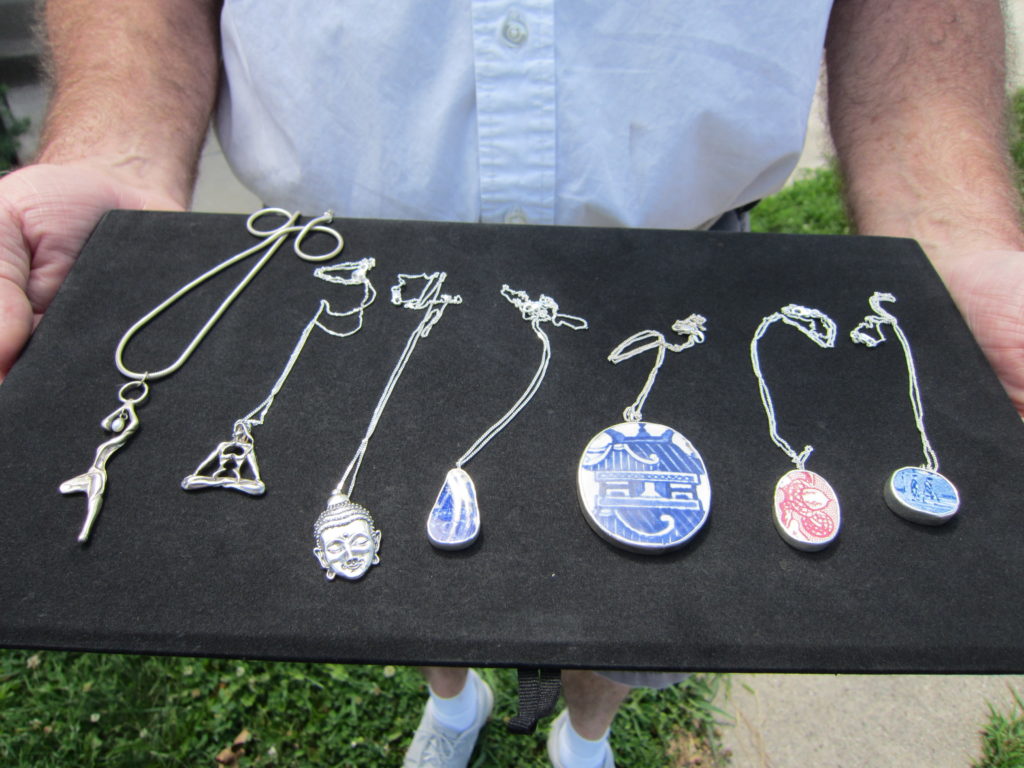 Allan LaBerteaux’s jewelry includes necklaces celebrating yoga (far left), and the type called “Chaney,” which employs pieces of china (three on the right). Photo by: John Carlson