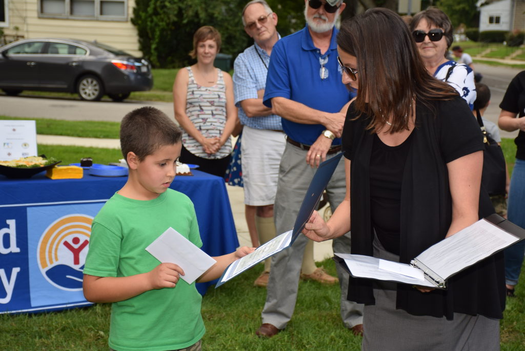 Jenni Marsh presents Tristan Parks from Royerton Elementary with a prize for his winning entry, permanently naming the bison "Neolin." Photo by: Mike Rhodes