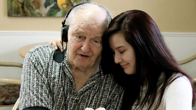 Athena Nagel, a Music & Memory volunteer, comforts Gene Hart, a Muncie Alzheimer’s patient, during a therapeutic iPod music session. Photo provided.