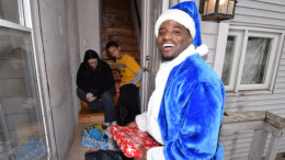 Officer Quintin Cooper is pictured delivering Christmas gifts to local children, Thursday afternoon. Officer Cooper used play football for the Ball State Cardinals. Photo by: Mike Rhodes