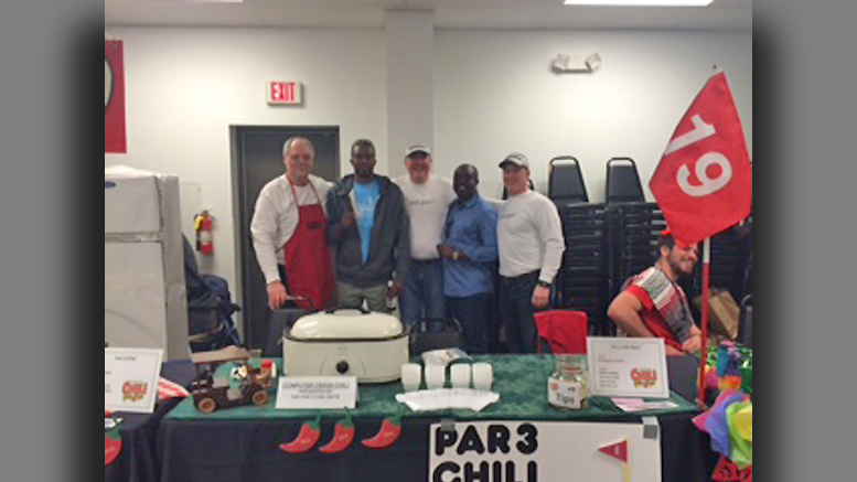 “The Par 3 Chili Boys” pose with visitors from Haiti. L-R Mark Flodder, Assene Guibert (Library Manager in Haiti), Ray Conley, Rev. Pedro Gaguerre (Pastor at St. Michael’s in Haiti) and Wes Russell. The name of their chili was “Computer Crash.” (Turns out that one of their secret ingredients was Spam.) Photo by: Carole Clohessy