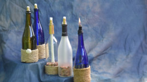 A variety of repurposed wine bottles turned into candle tiki-torches. Photo by: Mike Rhodes