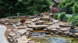 A beautiful and tranquil water feature is pictured in this outdoor setting created by Tell Three Friends. Photo by: Susie Burns