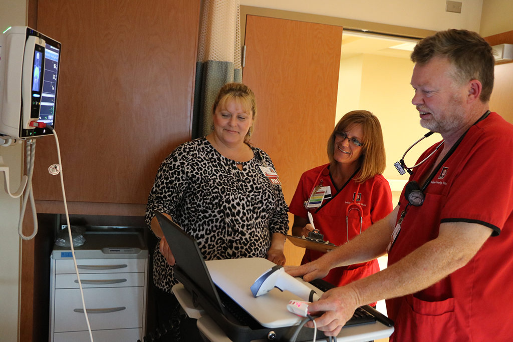 resa Elliott, Clinical Operations Manager at IU Health Ball Memorial Hospital works alongside nurses on 9N as they look into a patient’s care.