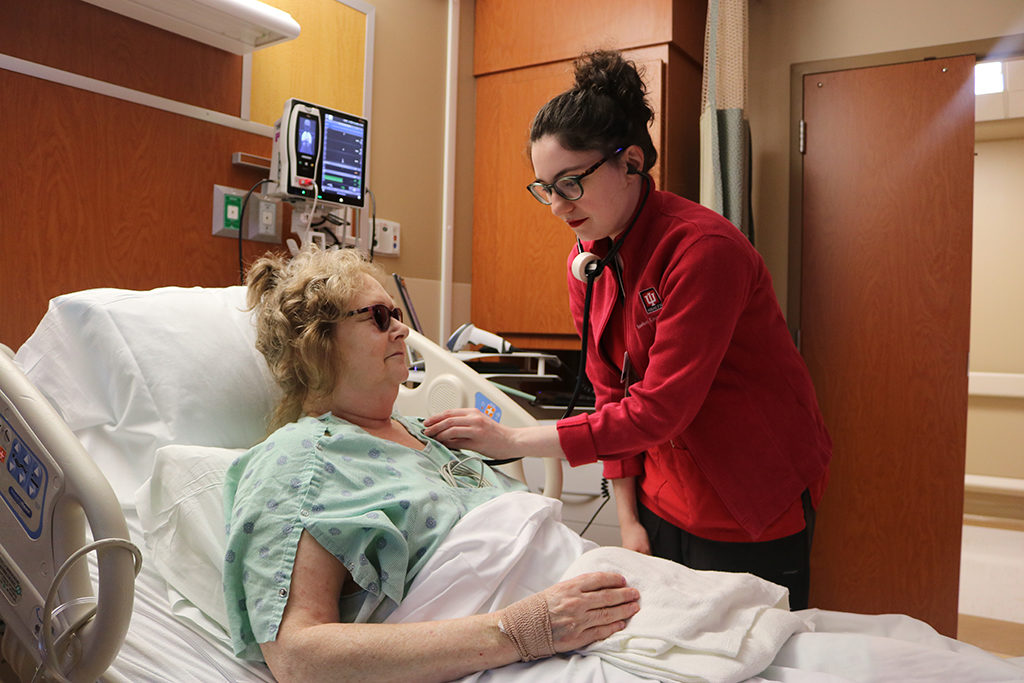 A nurse on the newly remodeled 9N Adult Surgical Unit checks a patient’s vital signs during morning rounding.