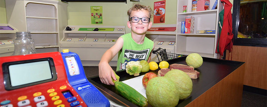 Dimitri Mali explores the Marsh Mini-Market inside the Muncie Children's Museum. Photo by: Mike Rhodes