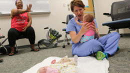 Dr. Melanie Schreiner, associate director at the IU Health Ball Memorial Family Practice and medical director of the CenteringPregnancy program, holds baby Artemis as she waves to her mother, Miranda. CenteringPregnancy is an innovative model of prenatal care that facilitates interactive learning and community building in a group setting. Photo provided.
