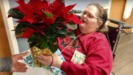 A resident is pictured with her poinsettia during "Project Poinsettia." Photo by: Liz Valpatic