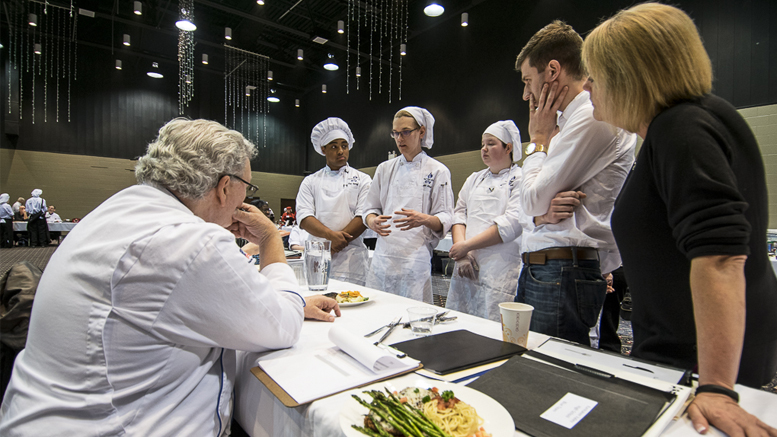 Culinary Arts students present their entry as a judge for the culinary competition listens to their presentation. Photo by: Mike Rhodes