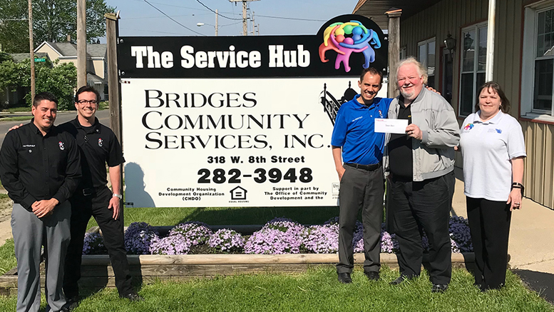 Belle Tire representatives present a check to Bridges Community Services. Photo provided.