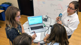 Laura Lauer looks on as a group solves a problem during a TechWise Academy middle school robotics class. Photo provided.