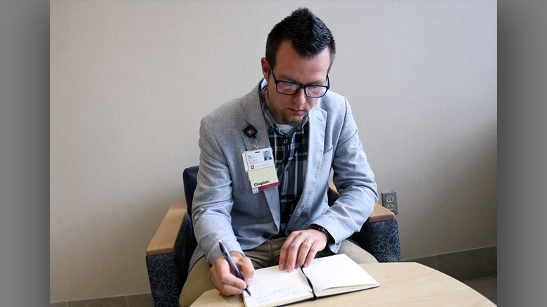 Rev. Will Grinstead, staff chaplain at IU Health Ball Memorial Hospital, takes time to make an entry in his journal. Photo by: Courtney Thomas for IU Health Ball Memorial Hospital.