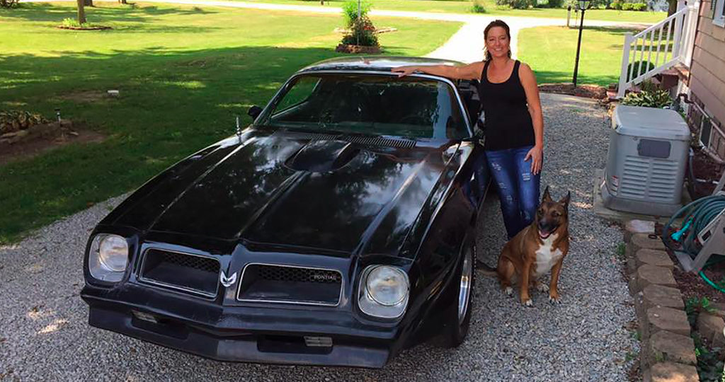 Debbe Caine and her vintage Pontiac Firebird.