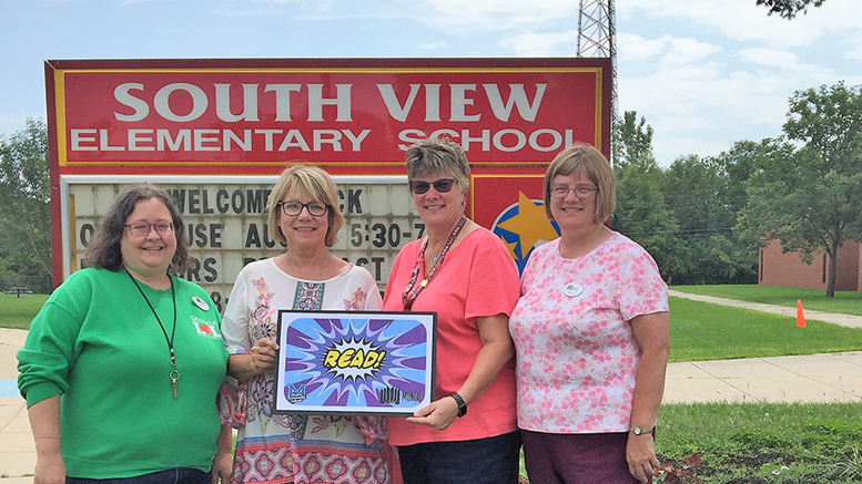 Muncie Public Library (MPL) content management coordinator Katherine Mitchell, Muncie Community Schools certified teacher librarians Rhonda Cowan and Melinda Sheffield, and MPL assistant director Beth Kroehler show off the UCAT Read! Card outside of South View Elementary School. Photo by: Akilah S. Nosakhere