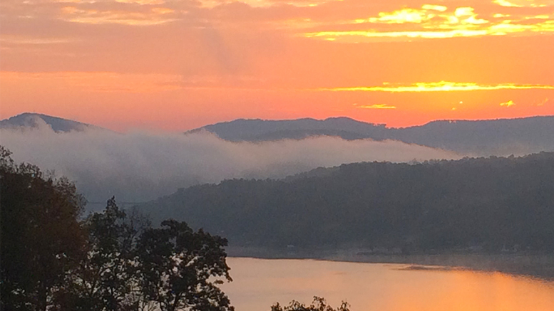 A peach-colored sunrise, reflected in Dale Hollow’s water. Photo by: Nancy Carlson