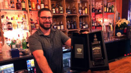 Bartender Joshua Banister shows off Frank Sinatra’s Jack Daniels. Photo by: John Carlson