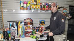 Firefighter Daniel Powell puts together a bag of new toys for a local family inside the Toys For Tots office in Southway Plaza. Photo by: Mike Rhodes