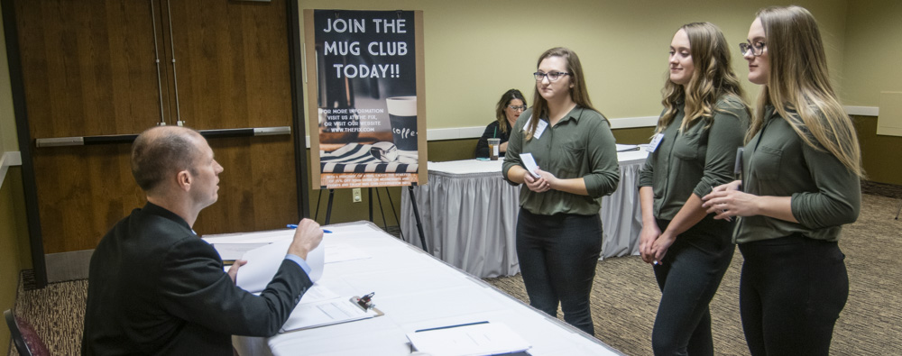 Students are pictured pitching a new restaurant concept to a STAR event judge.