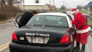 Muncie Police Officers are pictured on a stop handing out Christmas gifts to children. Photo by: Mike Rhodes
