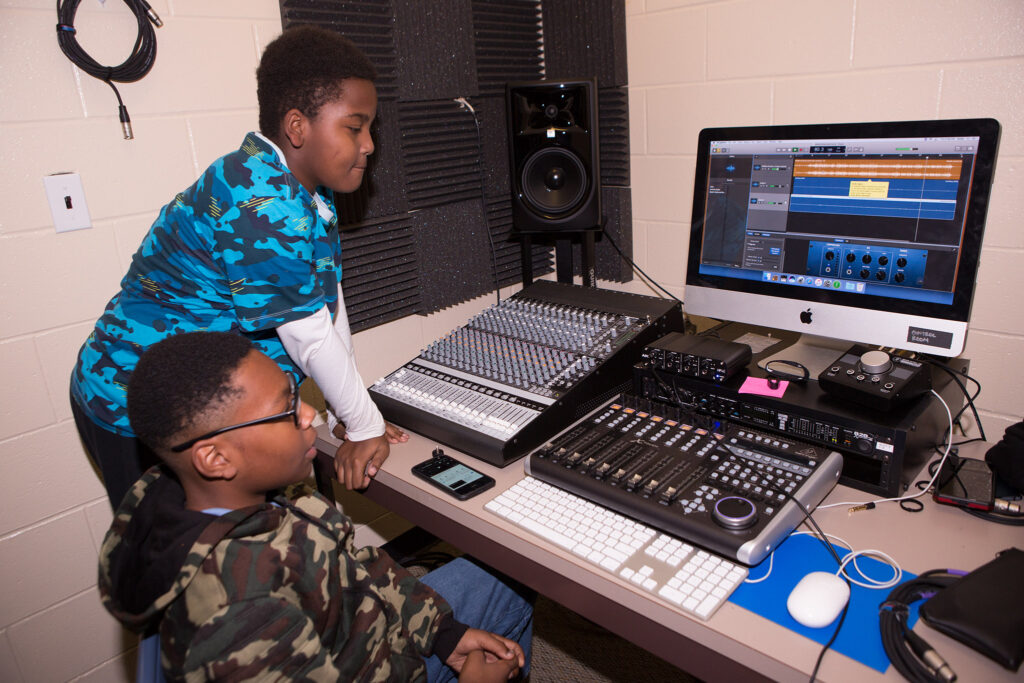 Middle schoolers Justin and X’zavier show each other their final projects in the making. Photo provided