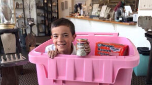Adam Hale is pictured inside a Feed My Sheep donation container at the offices of Heidi J Hale Designs on Walnut Street in downtown Muncie. Photo provided