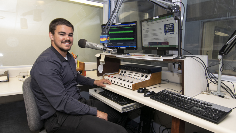 Ball State TCOM student Isaac Dirrim is pictured in the Woof Boom Radio News Center during his recent internship. Photo by: Mike Rhodes