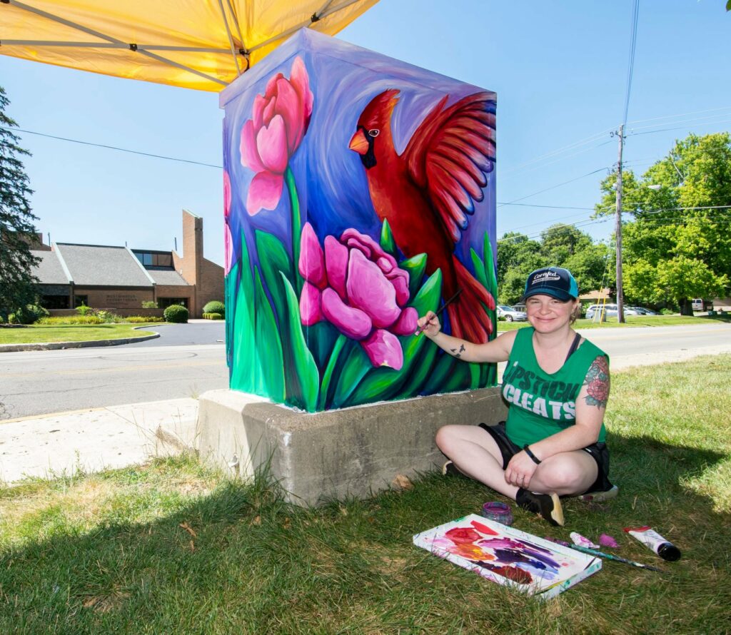Artist Sarah Shaffer is pictured finishing up her Muncie Arts and Culture Council “Box! Box!” project at the corner of Tillotson and Riverside Ave. Her art is titled: “To Bloom and Fly.” Photo by: Mike Rhodes