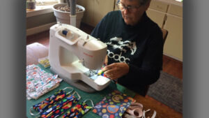 Volunteers like Nancy Carlson are among local theater seamstresses making masks. Photo by: John Carlson