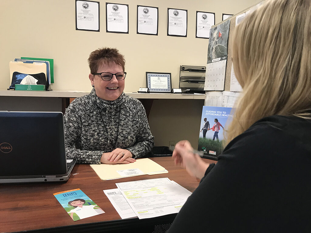 A navigator at Open Door Health Services offers free help enrolling a customer for healthcare coverage. Photo provided