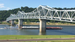 A powerful tugboat pushes barges past Madison’s Riverboat Inn. Photo by: Nancy Carlson