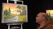 Artist Andy Klise admires a painting displayed at “Bob Ross Experience.” Photo by Nancy Carlson