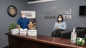 Steve Leach, Franchise Manager and Kiara Dunson, Administrative Assistant at Home Instead are pictured with a few boxes of masks supplied by Mayor Ridenour's "Masks for Muncie" project.The company received 1,250 masks. Photo by Mike Rhodes